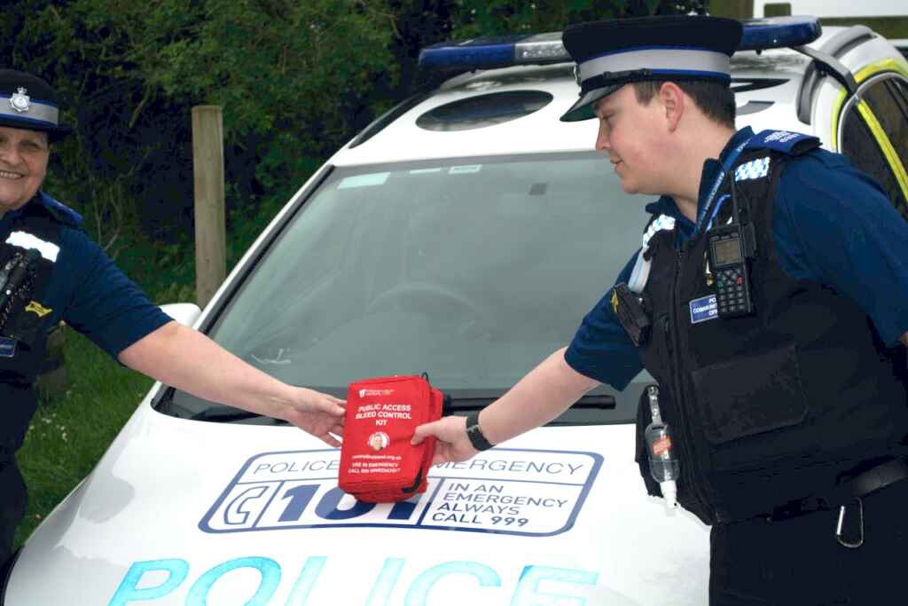 Two police officers in front of a police car