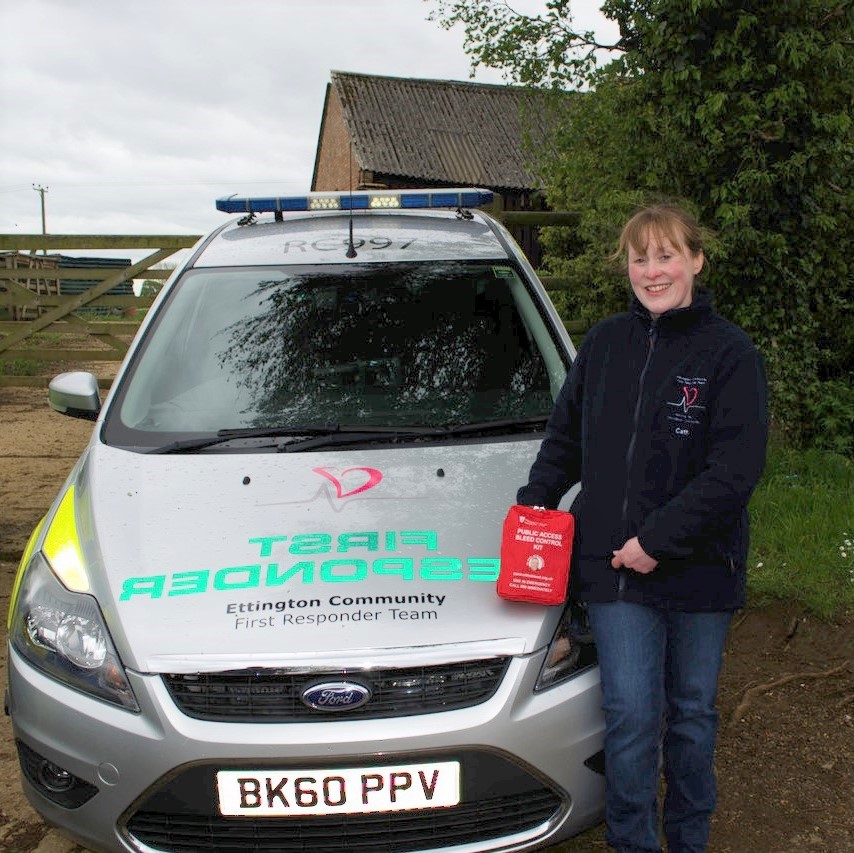 Womsn standing next to an ambulance car