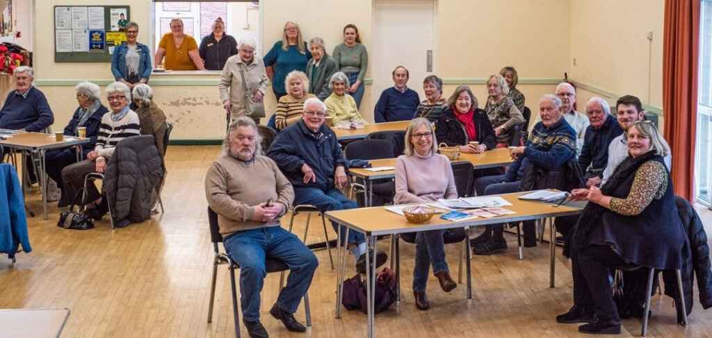Large group of people meeting in a village hall